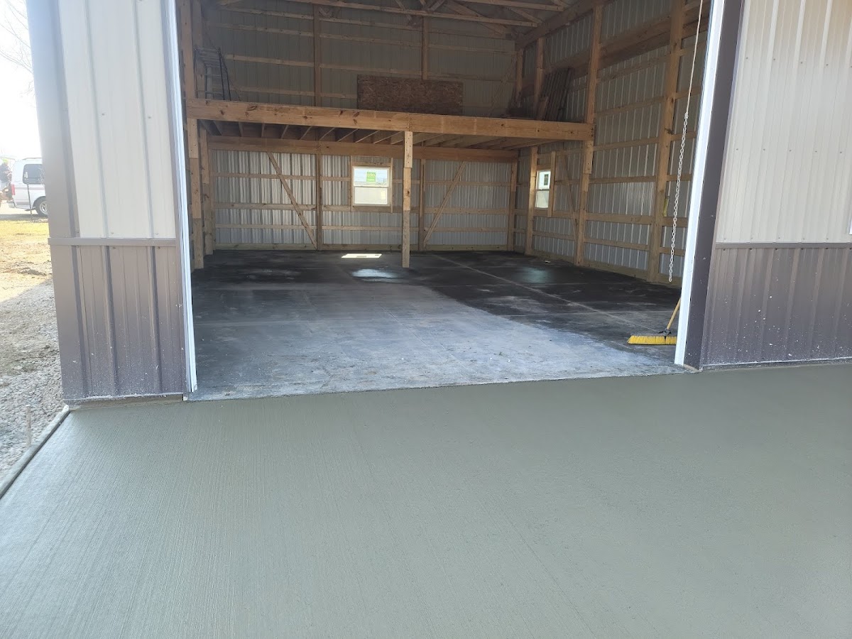 Fresh concrete apron poured outside a pole barn garage